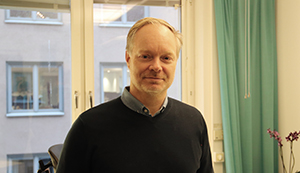 man stående mot fönster