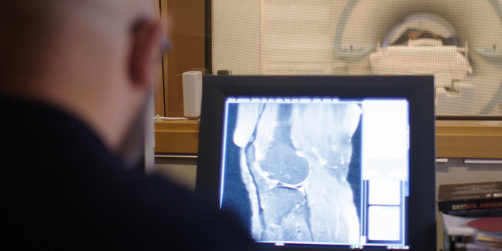 rmv-rättsmedicin-man tittar på röntgenbild på knäled