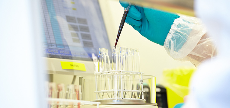 Hand som använder en pipett i ett provrör